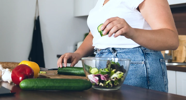 woman puring veggies in bowl